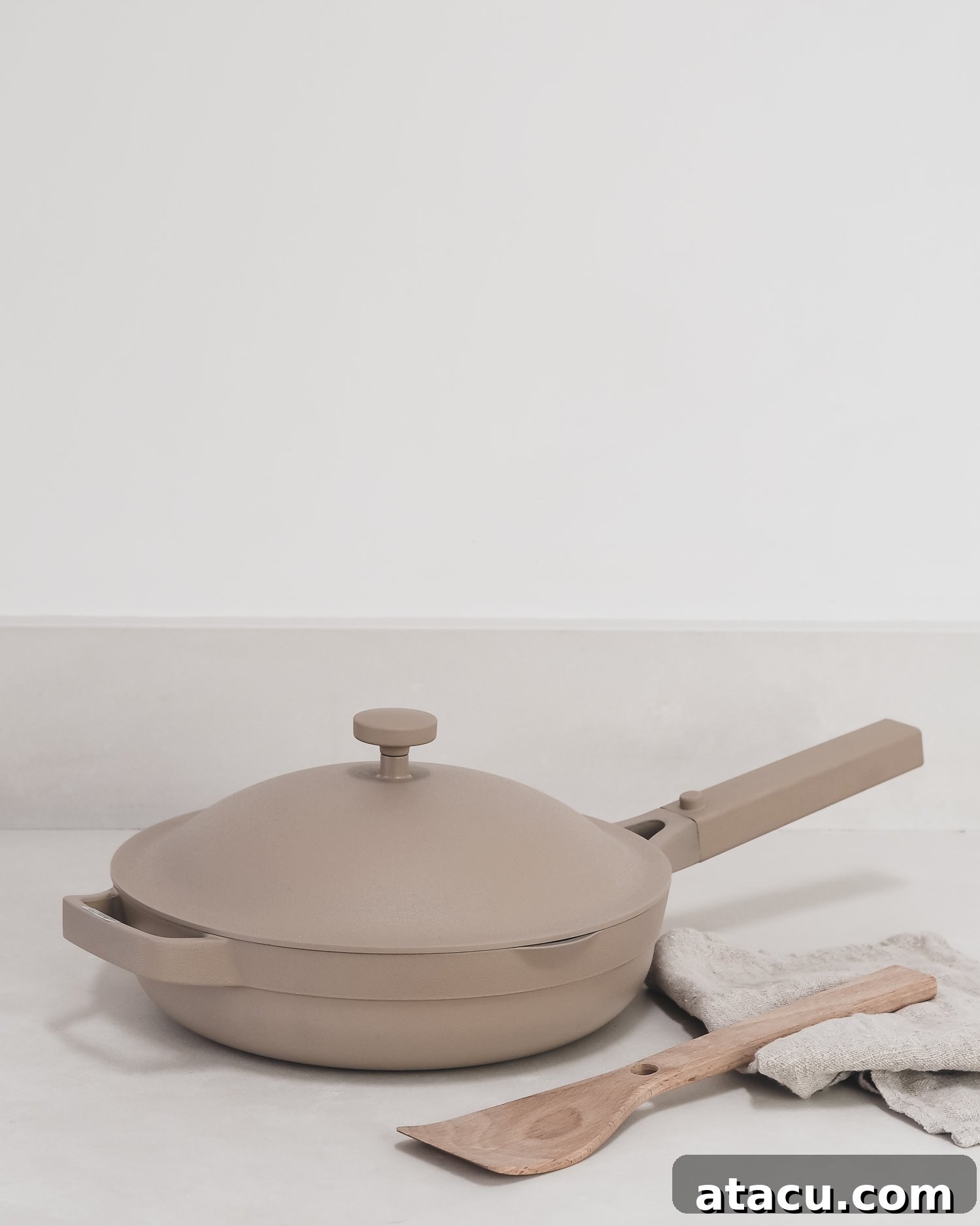 The iconic beige Always Pan by Our Place, designed to replace eight traditional cookware pieces, resting on a clean kitchen countertop.