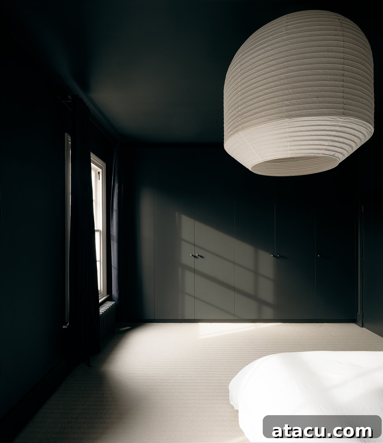 Dark black bedroom with a large white paper lantern light fixture