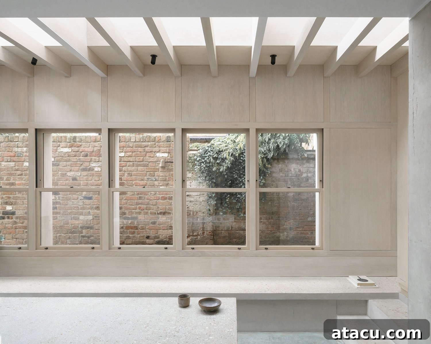 Another angle of the living space with concrete benches and a large skylight