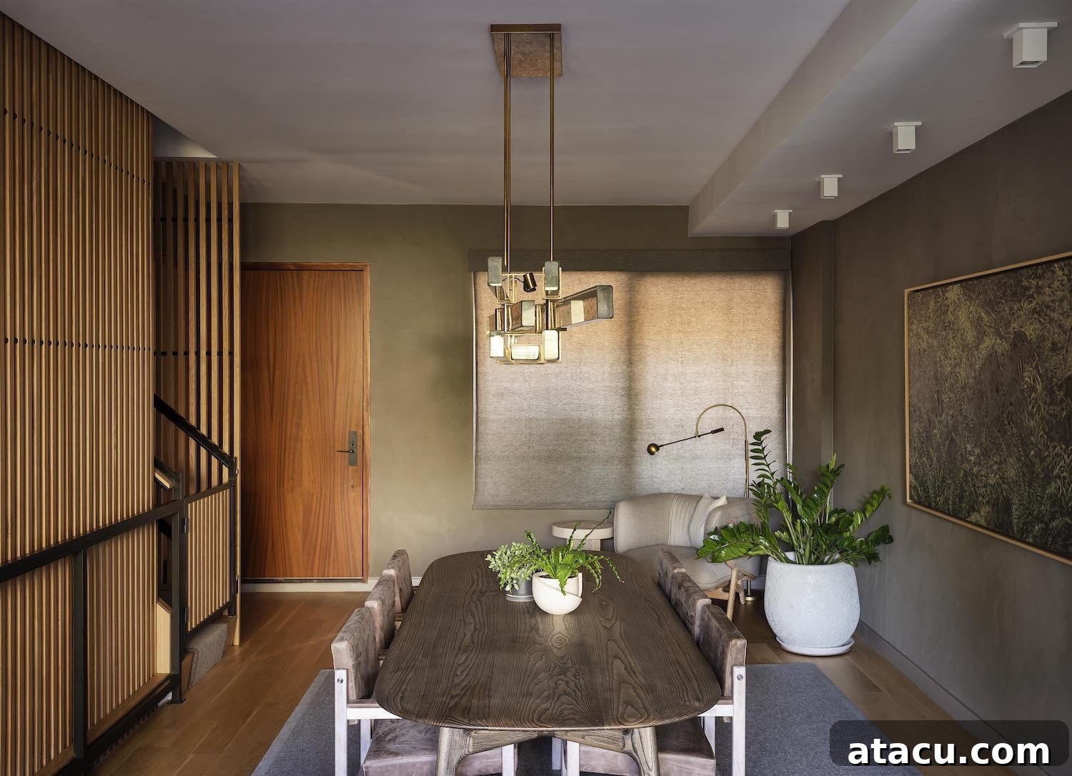 Elegant dining room in a Williamsburg townhouse with natural wood table, upholstered chairs, and a large plant.