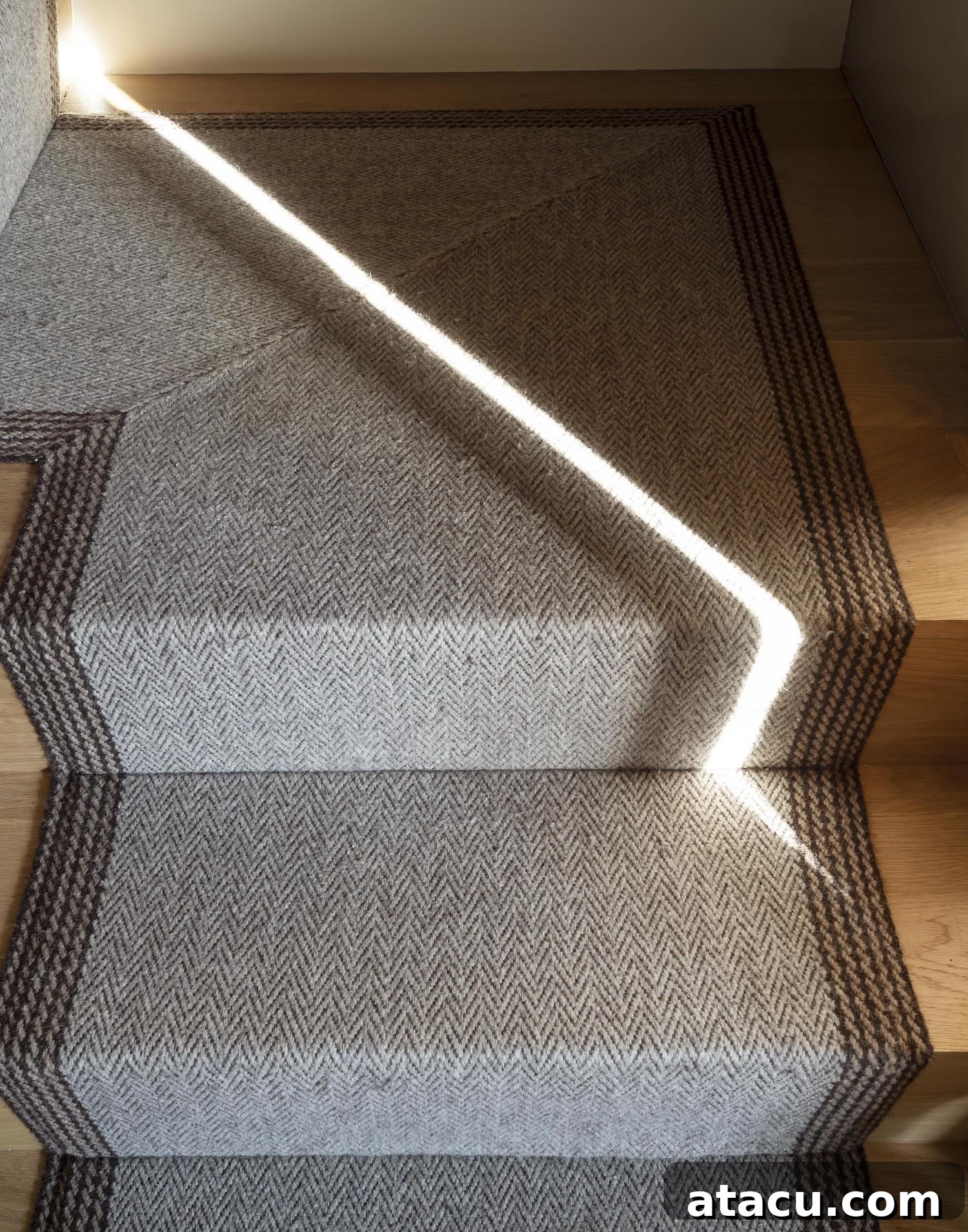 Close-up detail of the modern staircase, highlighting the craftsmanship of wood and textured wall finishes.
