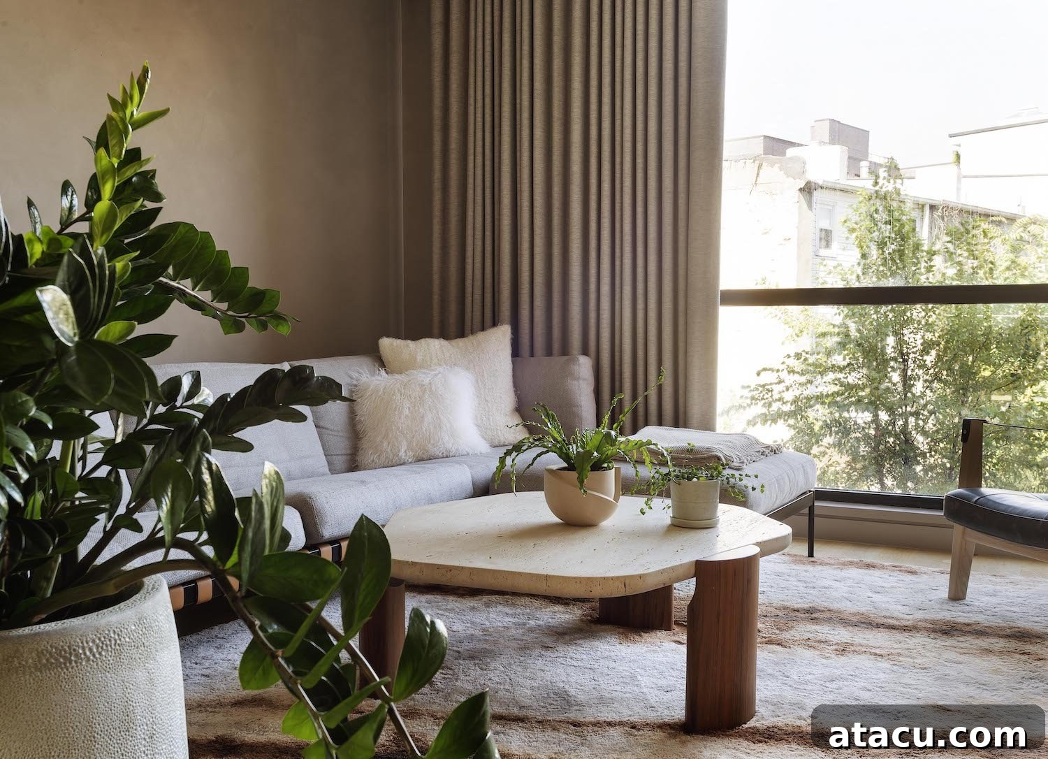 A serene living room, designed for comfort and connection with natural elements and ample light.