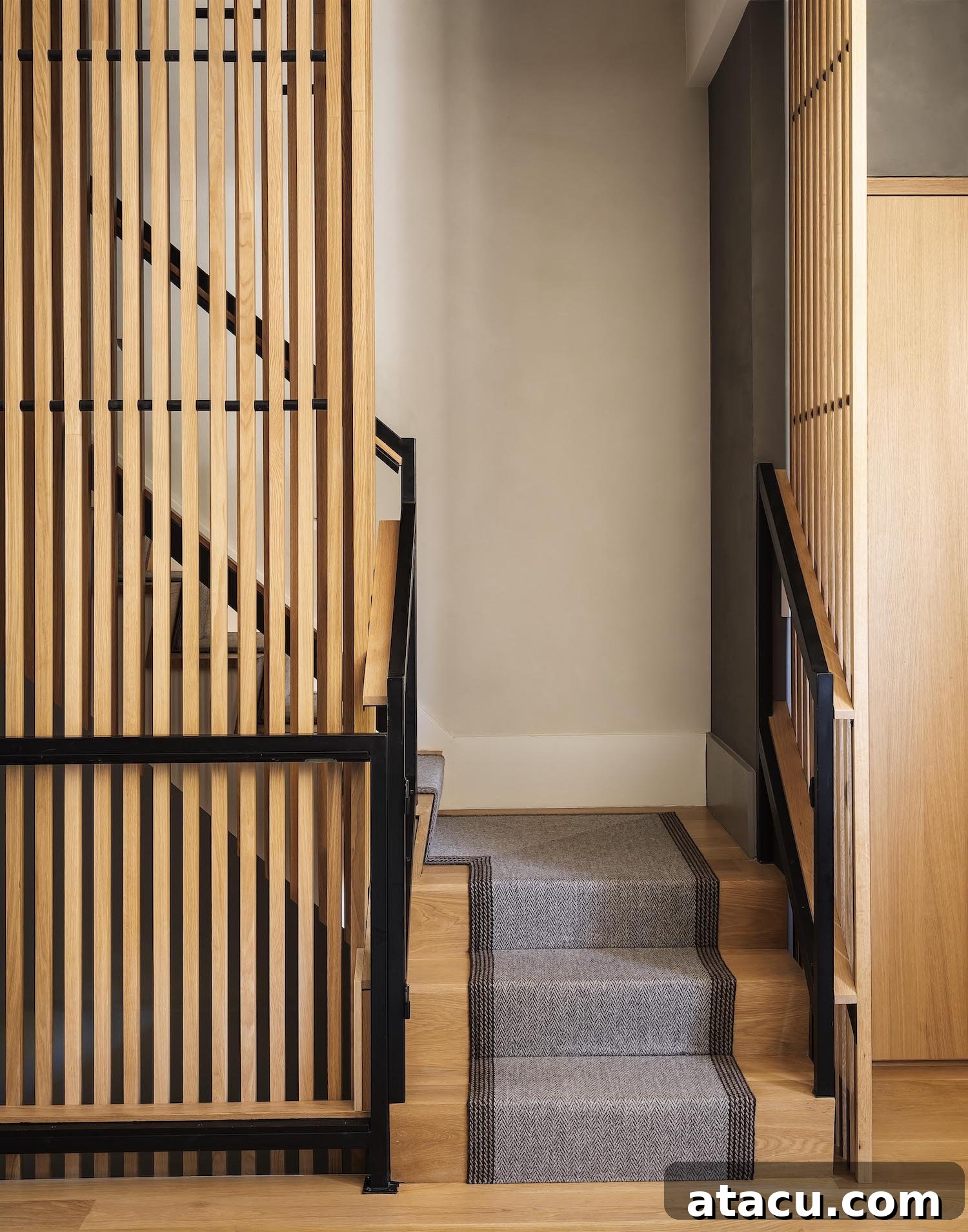 Modern staircase with natural wood treads and textured walls in a Brooklyn townhouse.