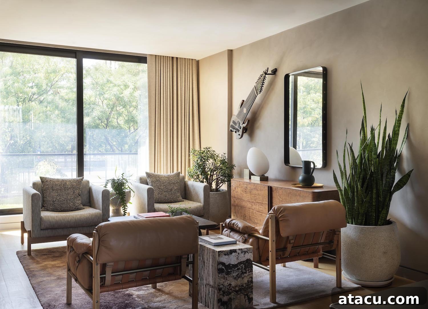 Spacious living room with a large, textured sofa, natural wood coffee table, and abundant greenery.