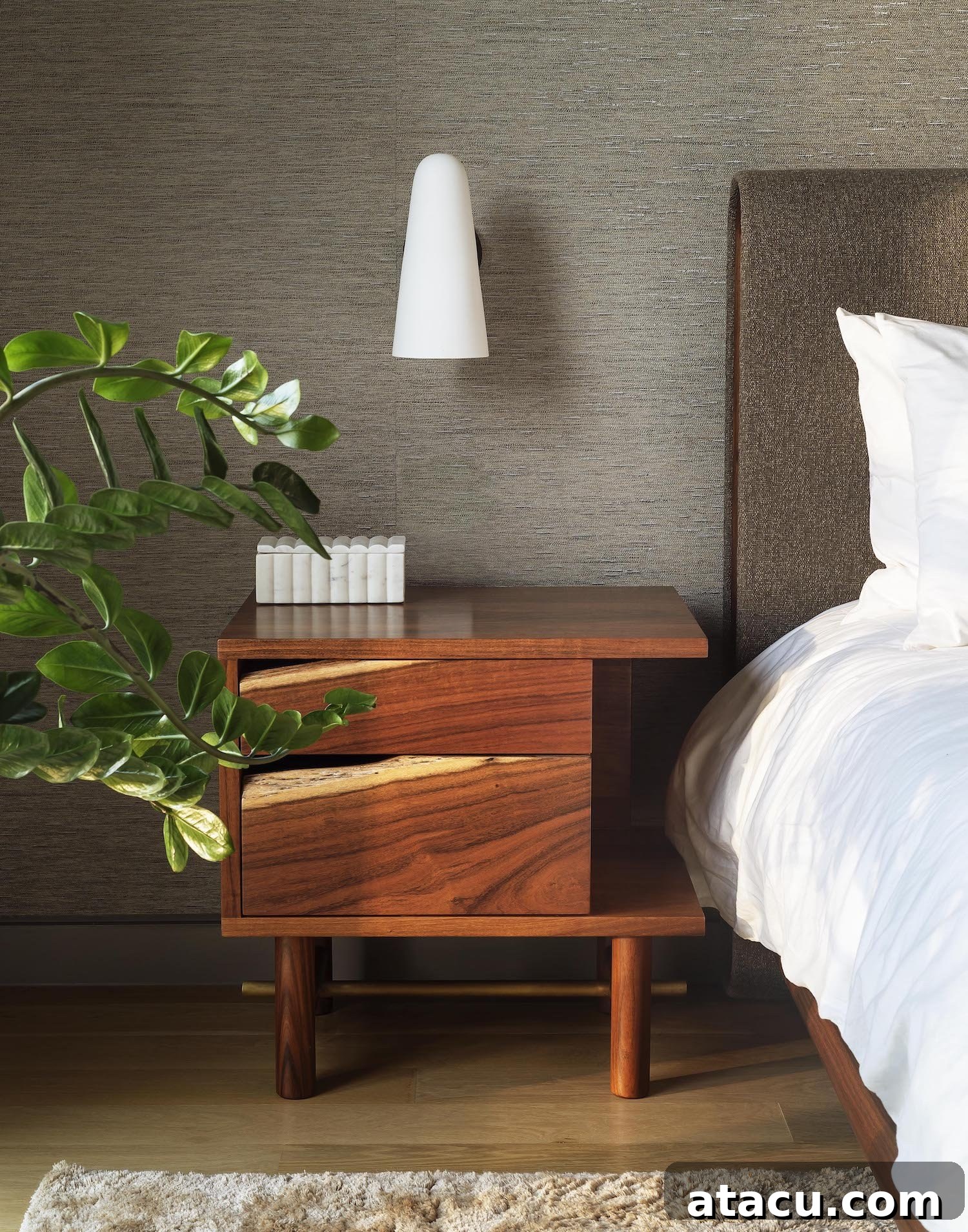 Close-up of a master bedroom detail, showing layered natural textures on bedding and a soft, inviting color scheme.