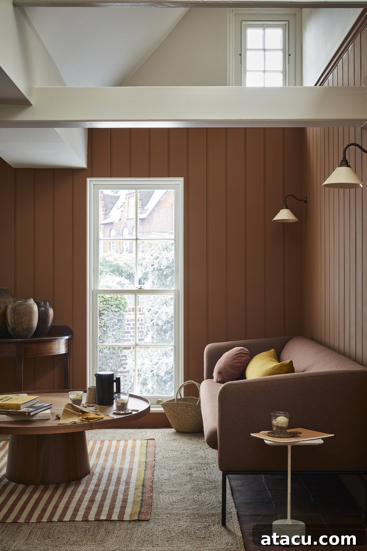 An elegant interior space with walls painted in Little Greene Affogato, a creamy neutral hue, complemented by Slaked Lime – Mid on the ceiling and window trim.