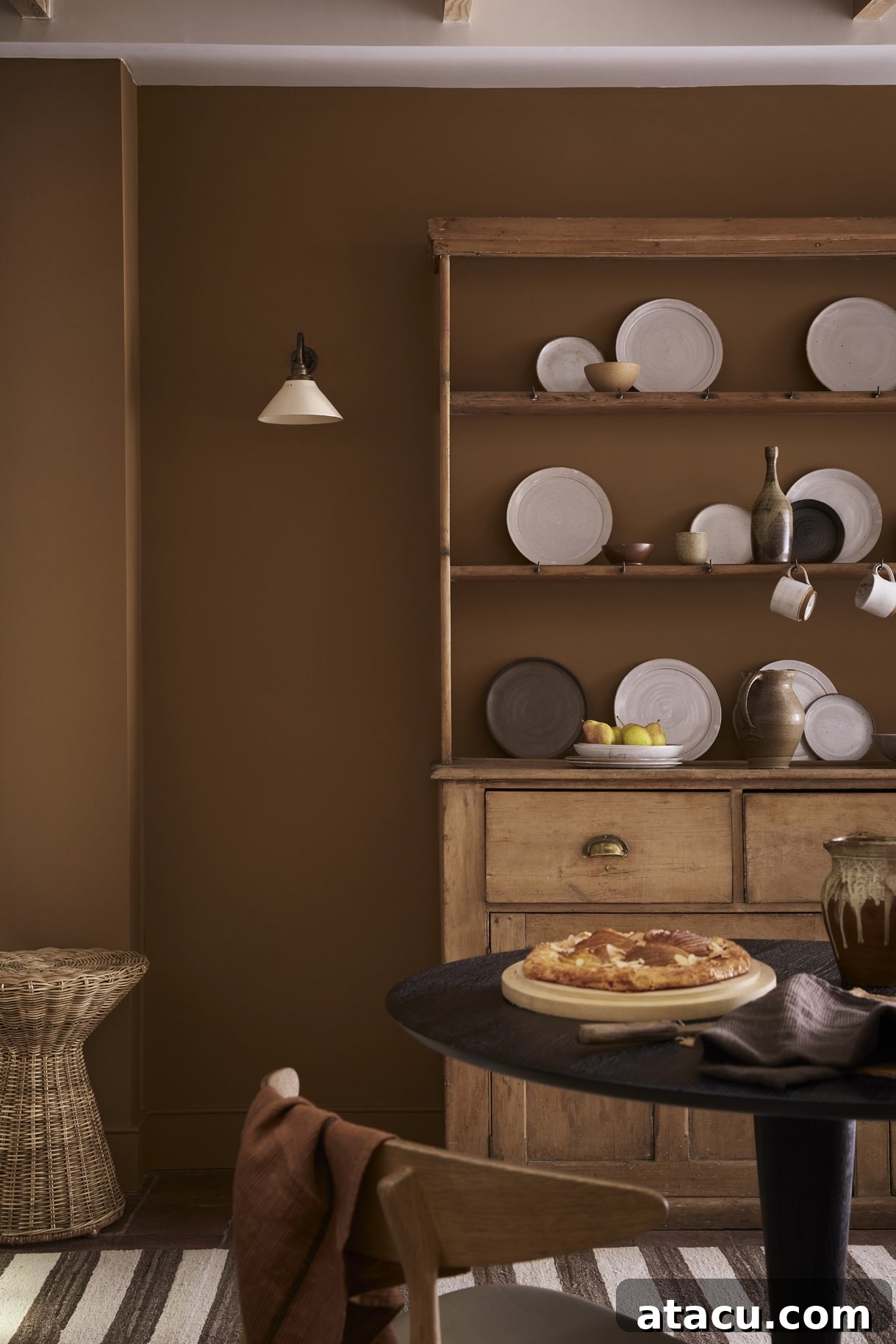 A serene room with walls elegantly painted in Little Greene Galette, a warm, golden-brown hue that brings depth and comfort to the space.