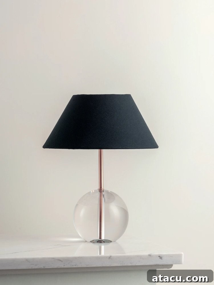 Feya glass table lamp with a crystal glass ball base, brushed brass stem, and a bold silhouette.