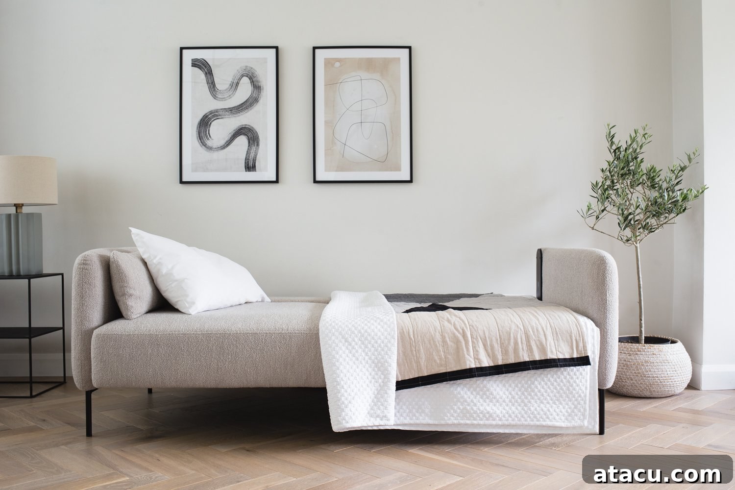 a modern sofa bed made up with throws and pillows