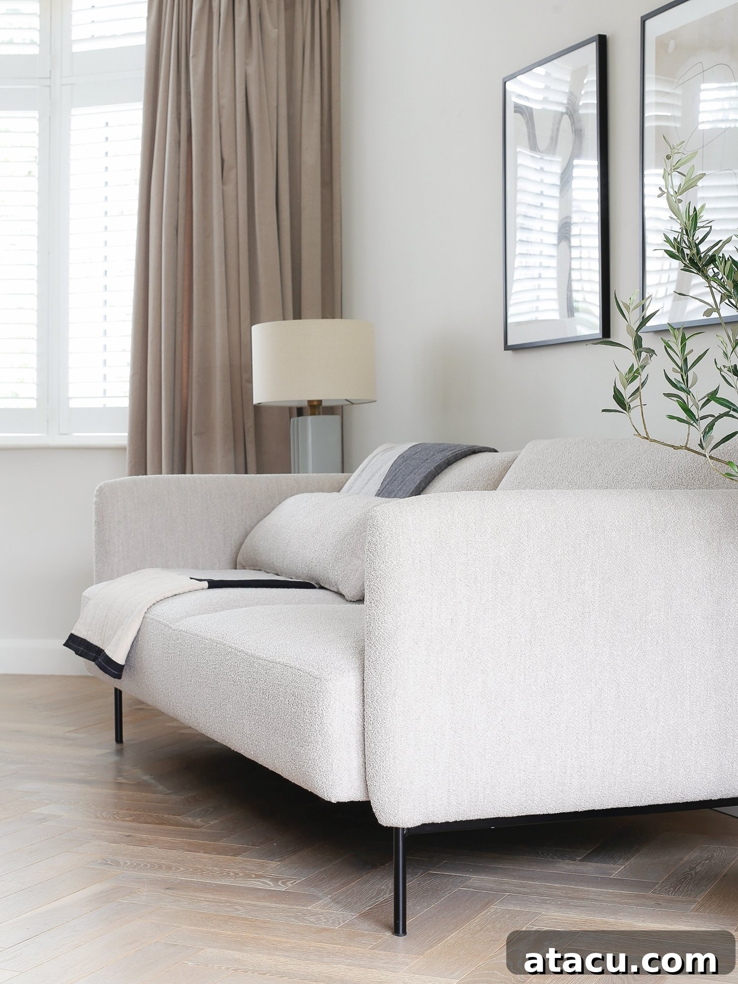 A side view of a boucle modern sofa bed in a minimalist living room