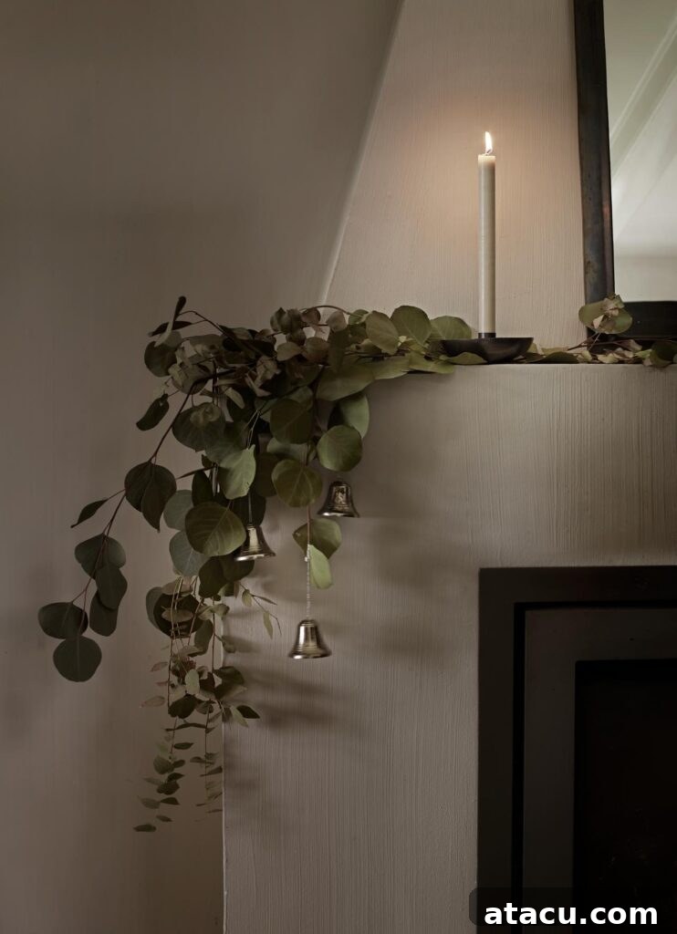 A beautifully simple eucalyptus garland gracefully draped along a mantlepiece, creating a serene natural Christmas decoration.