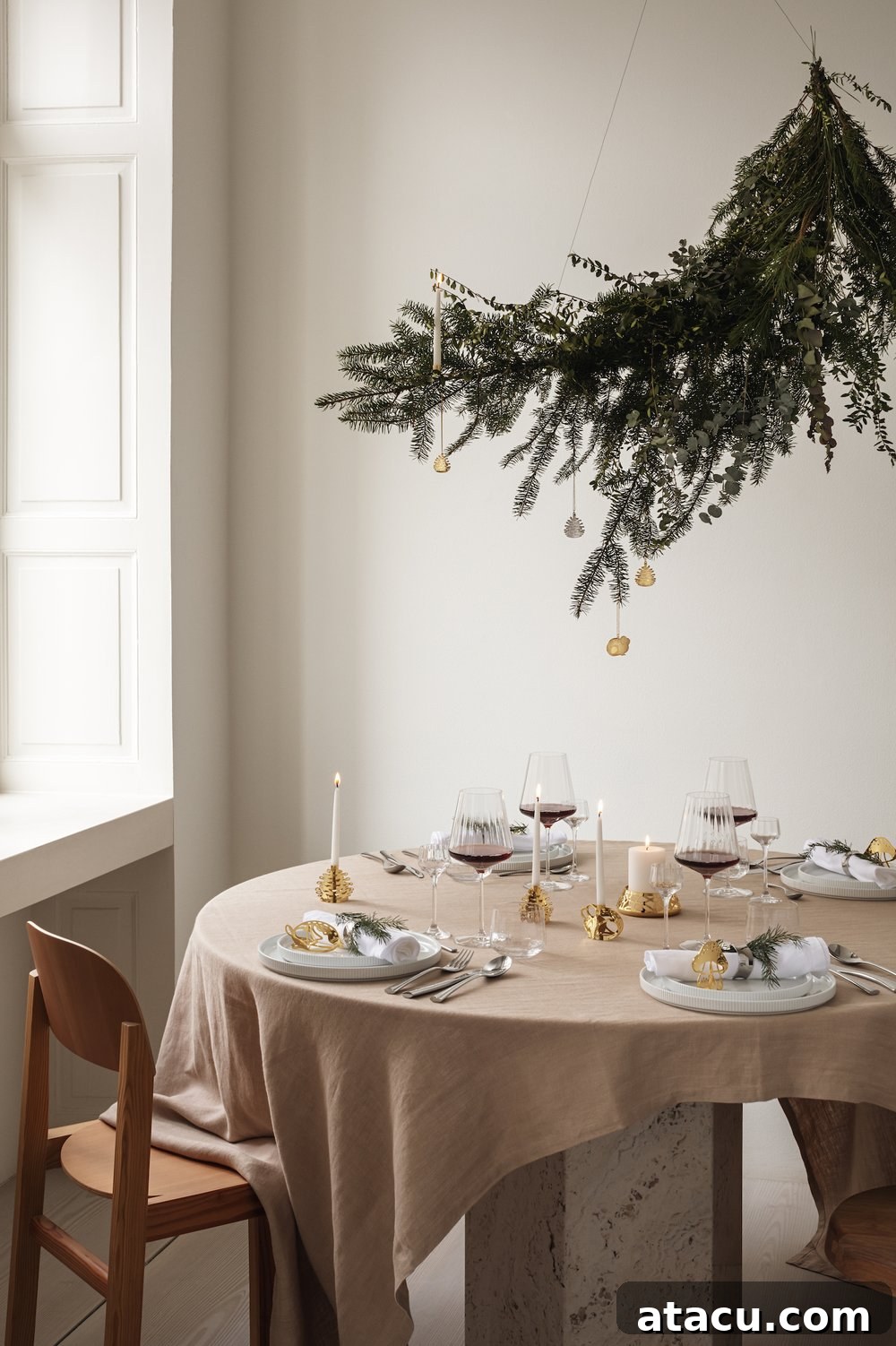 A festive table setting featuring a natural branch decoration artfully suspended above, creating an enchanting focal point.