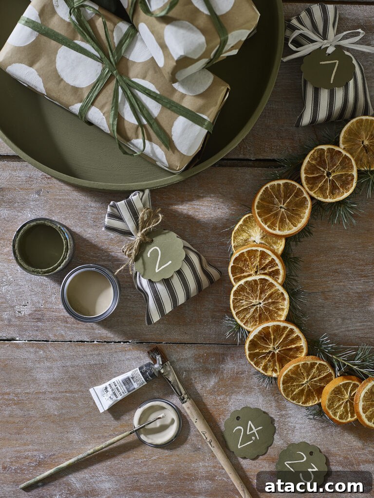 Rustic natural Christmas decorations featuring dried orange slices and fresh rosemary sprigs, ready for hanging.