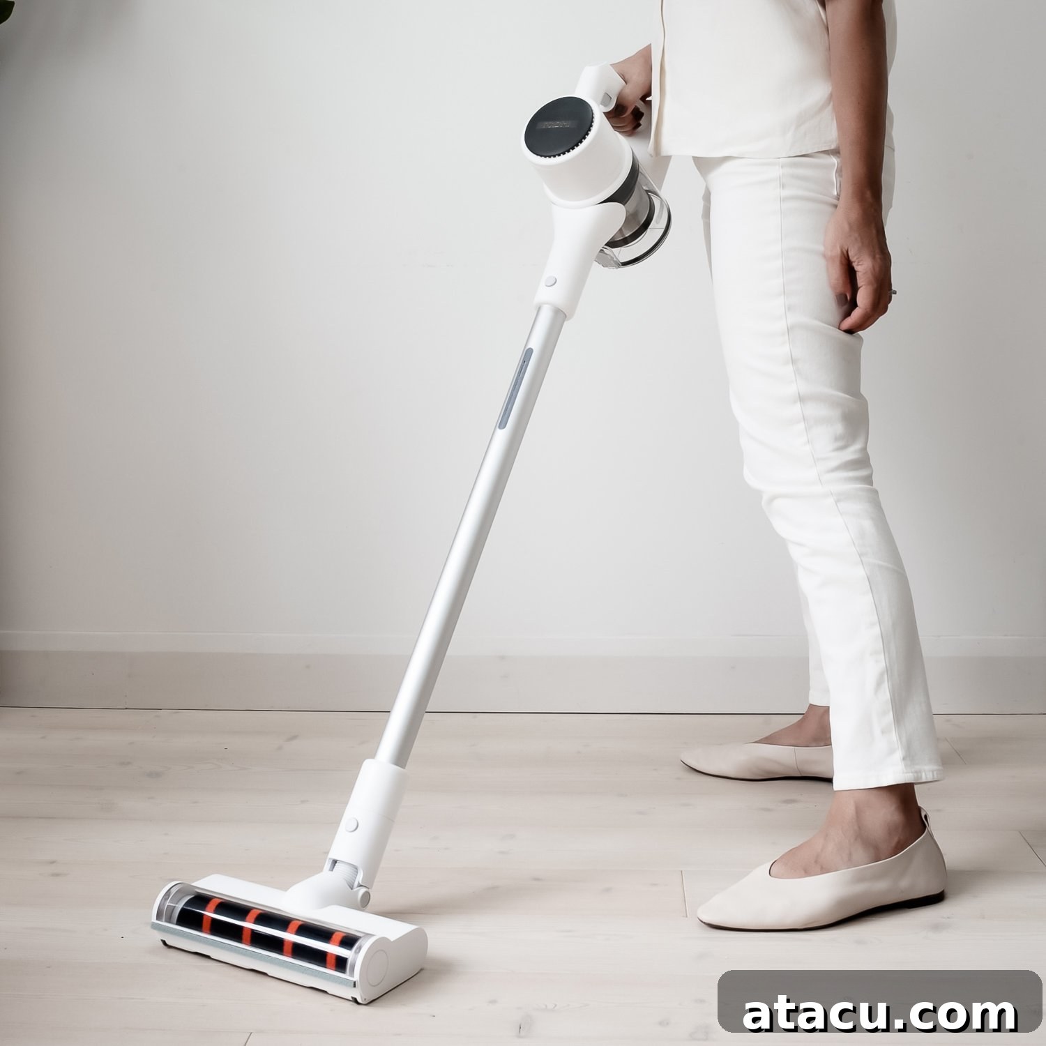 A person vacuuming a clean floor with a modern cordless vacuum cleaner