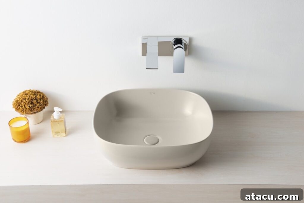 A modern beige coloured bathroom sink with minimalist design, set against a subtle backdrop.