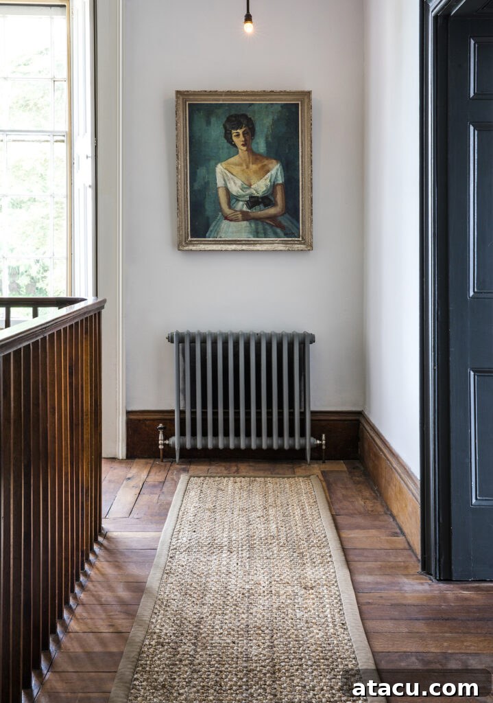 A staircase landing with wood floors, a textured runner, and a vintage painting.