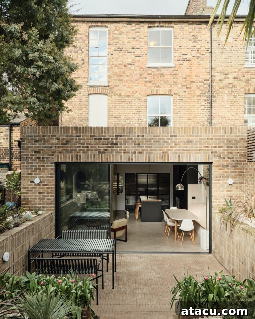 21 Jaw-Dropping Kitchen Extension Designs 4 A modern kitchen extension featuring large sliding doors that seamlessly connect the interior with an outdoor garden space.
