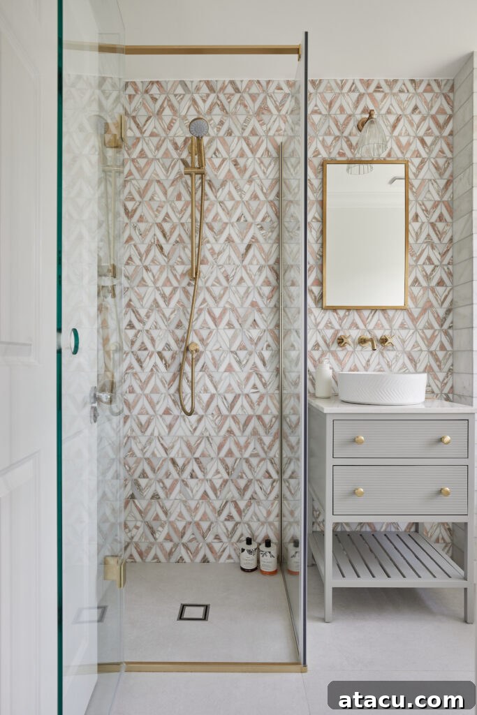 A pastel-coloured small bathroom featuring a vanity unit and shower, beautifully accented with decorative tiles.