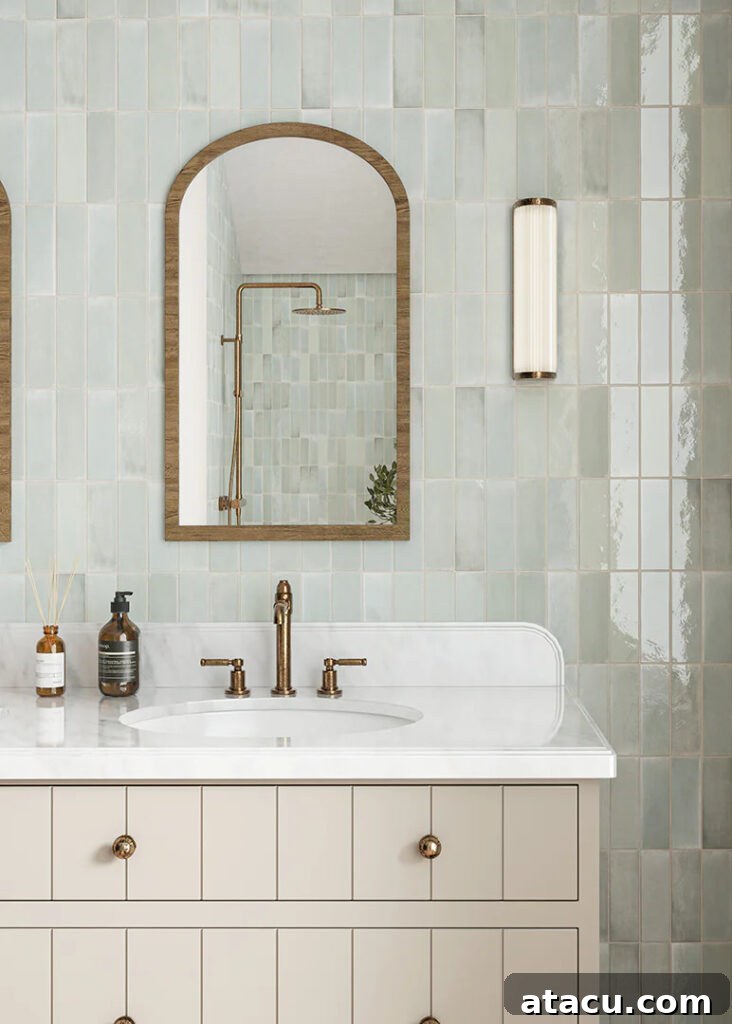 A charming small bathroom in pastel shades, featuring Pastello Seagrass Gloss Metro Tiles and a sleek vanity unit with a mirror.