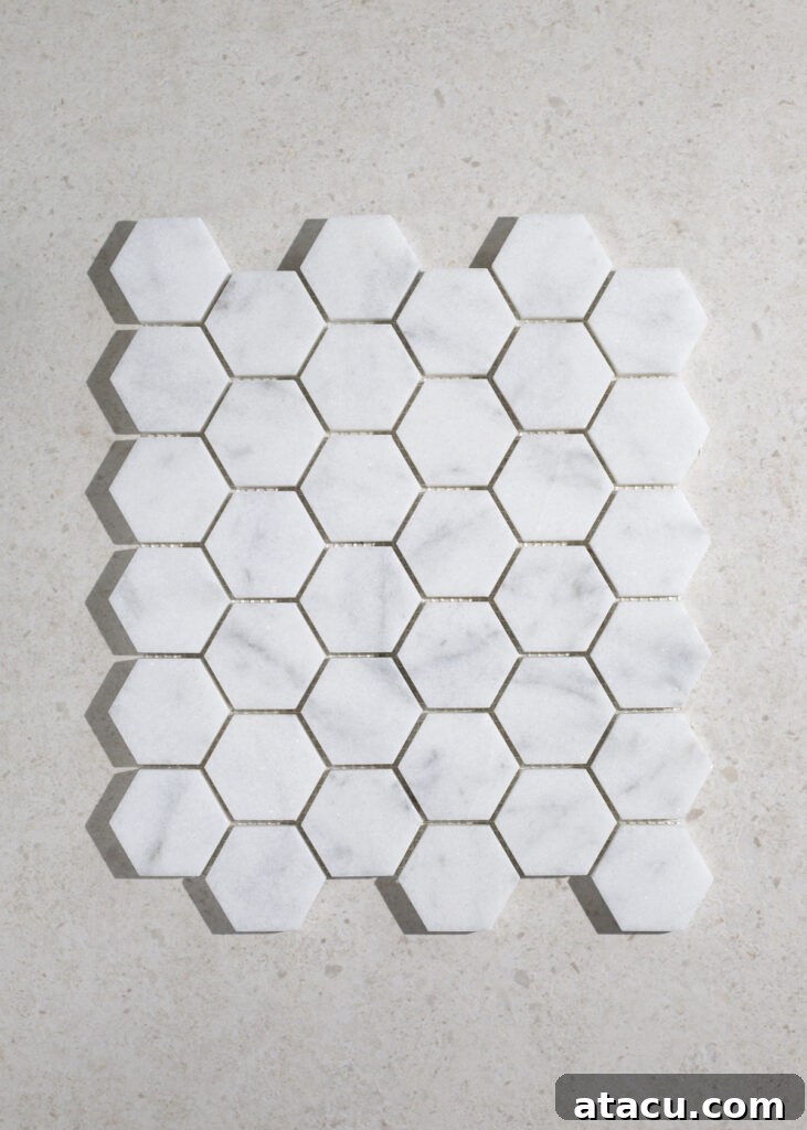 Elegant Carrara Bianco honed marble hexagon mosaic tiles adding unique character to a small bathroom wall.