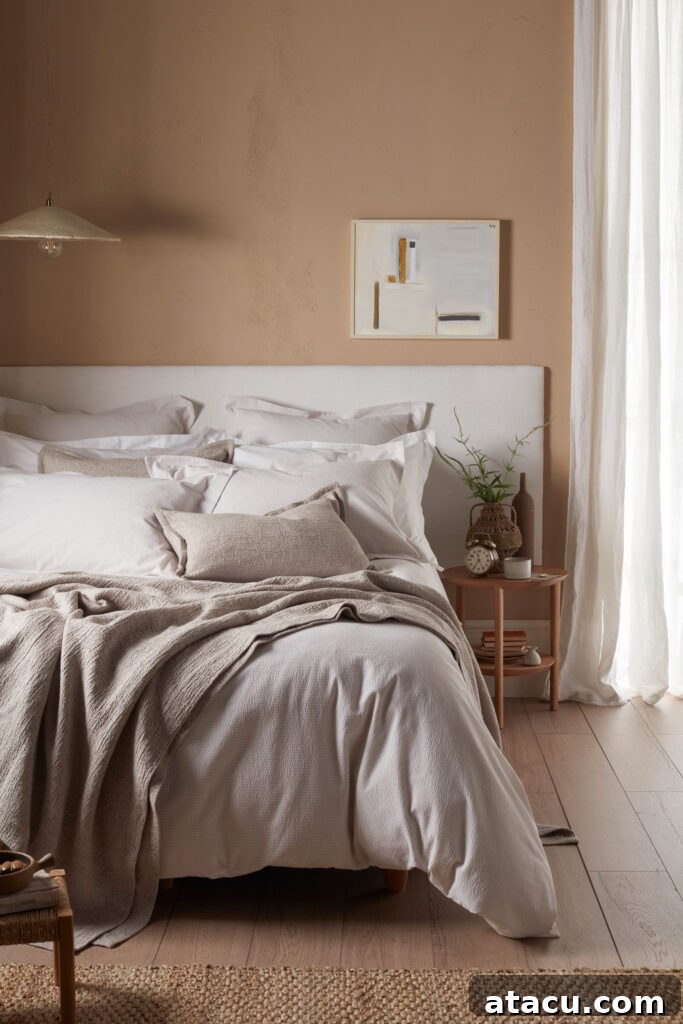 A cosy bedroom in a warm bedroom aesthetic with seersucker bed linen.