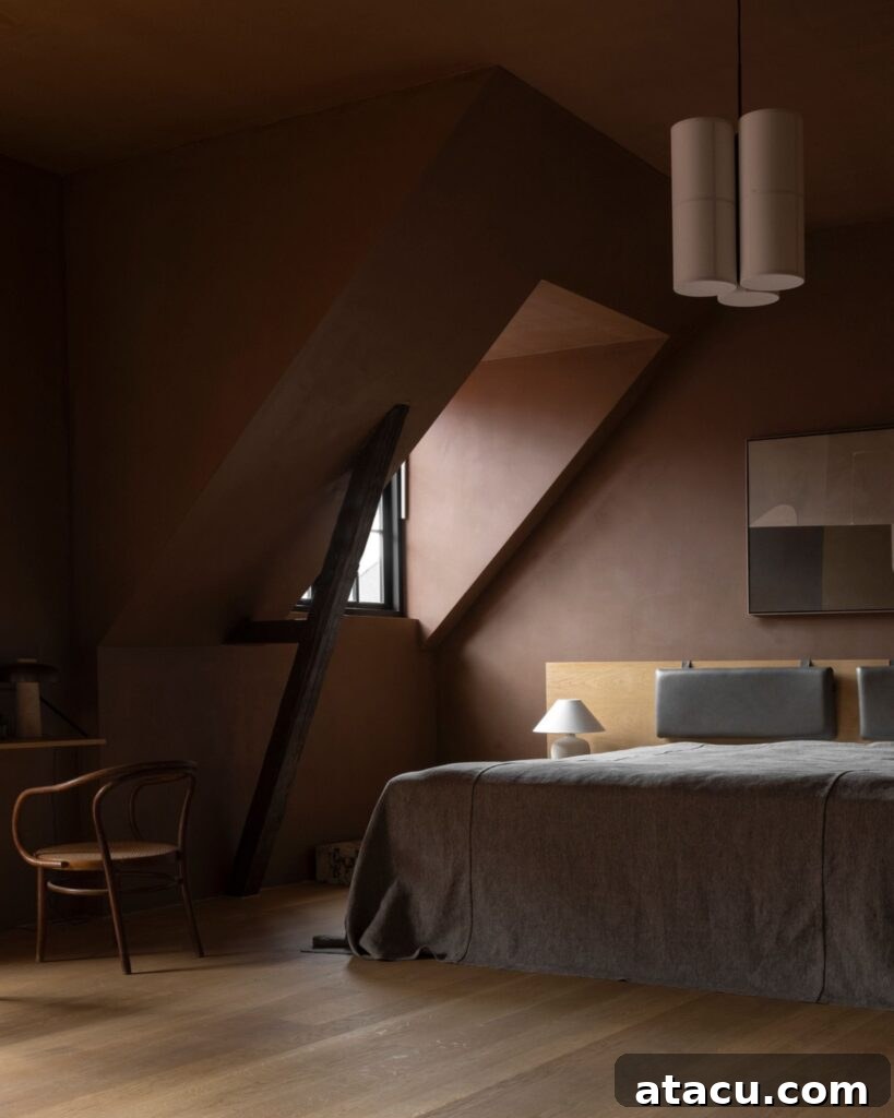 A dark rust red bedroom with a sloping ceiling showcasing a warm bedroom aesthetic.