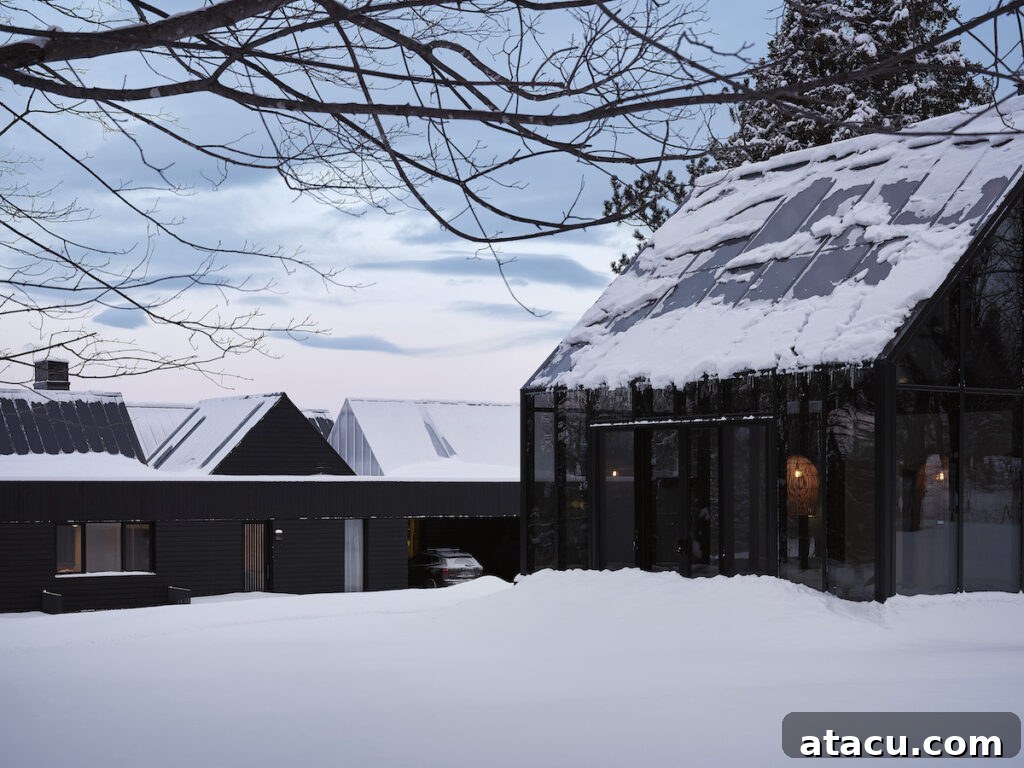 A modern black house in a snowy landscape.