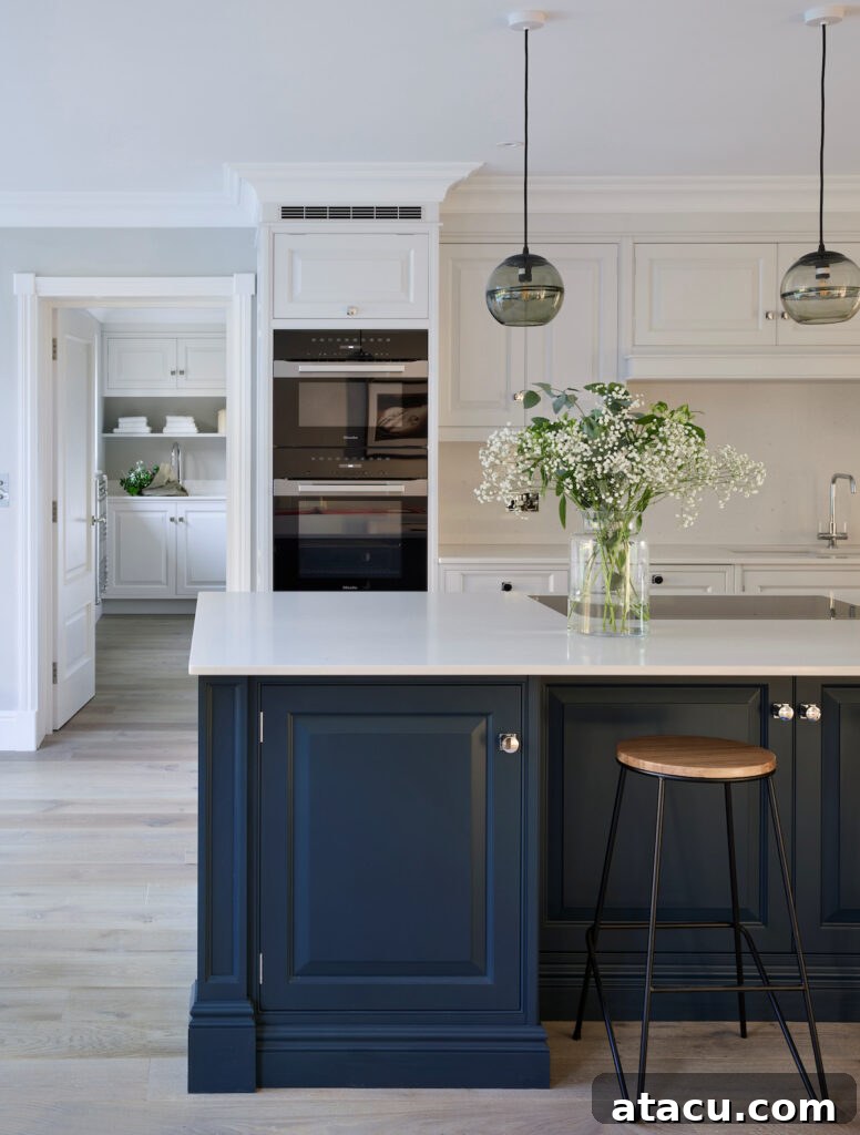 Kitchen island painted in Hague Blue by Farrow & Ball with Misty Carrera Quartz worktops by Caesarstone.