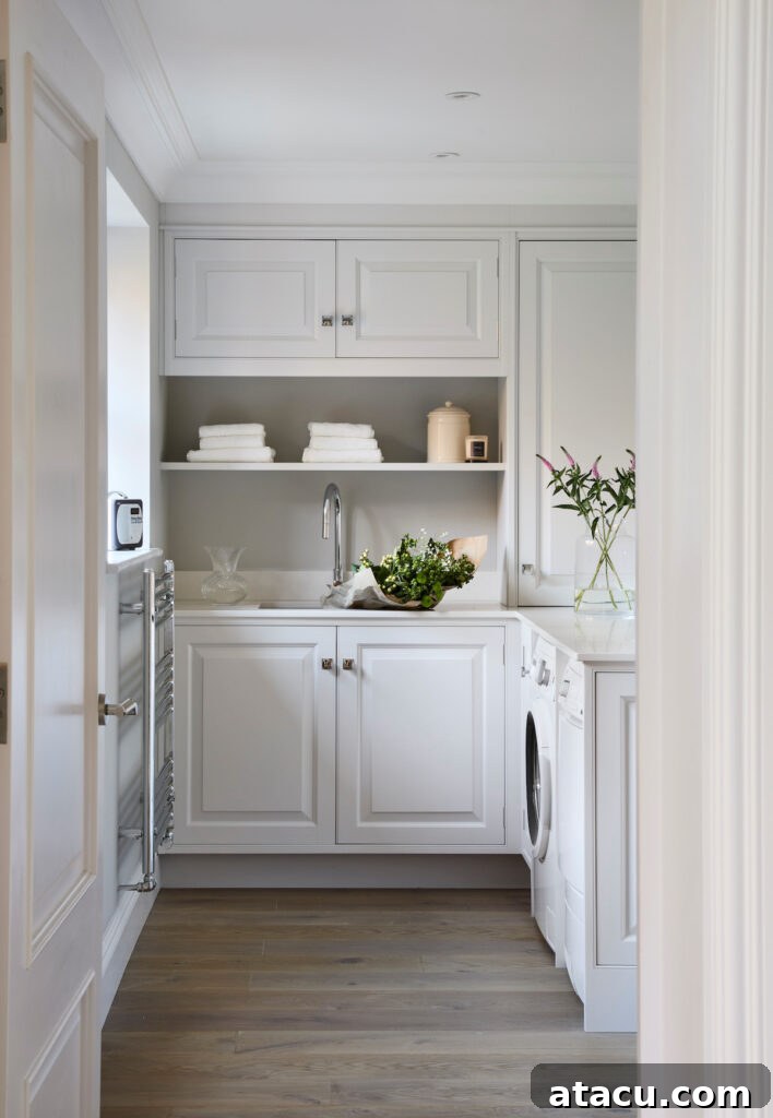 A bespoke utility room featuring handmade overhead and undercounter cabinetry with decorative open shelving and freestanding appliances, handpainted in Blackened by Farrow & Ball.