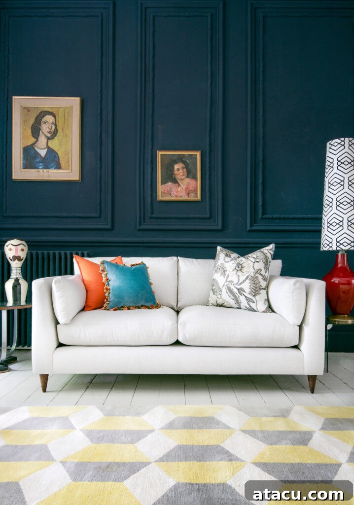 Unlocking Visual Appeal with Threes and Fives 3 A modern living room with dark blue panelled walls, a white sofa, colorful accent pillows, vintage framed paintings, and a geometric yellow and grey rug.