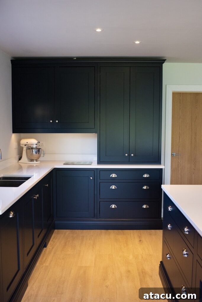 A dark blue Shaker style kitchen featuring floor-to-ceiling cabinets, showcasing modern small kitchen ideas with maximized vertical storage.