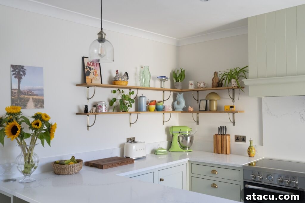 A charming small kitchen featuring pastel cabinetry, open shelving adorned with plants and decor, and a modern countertop, showcasing creative small kitchen ideas.