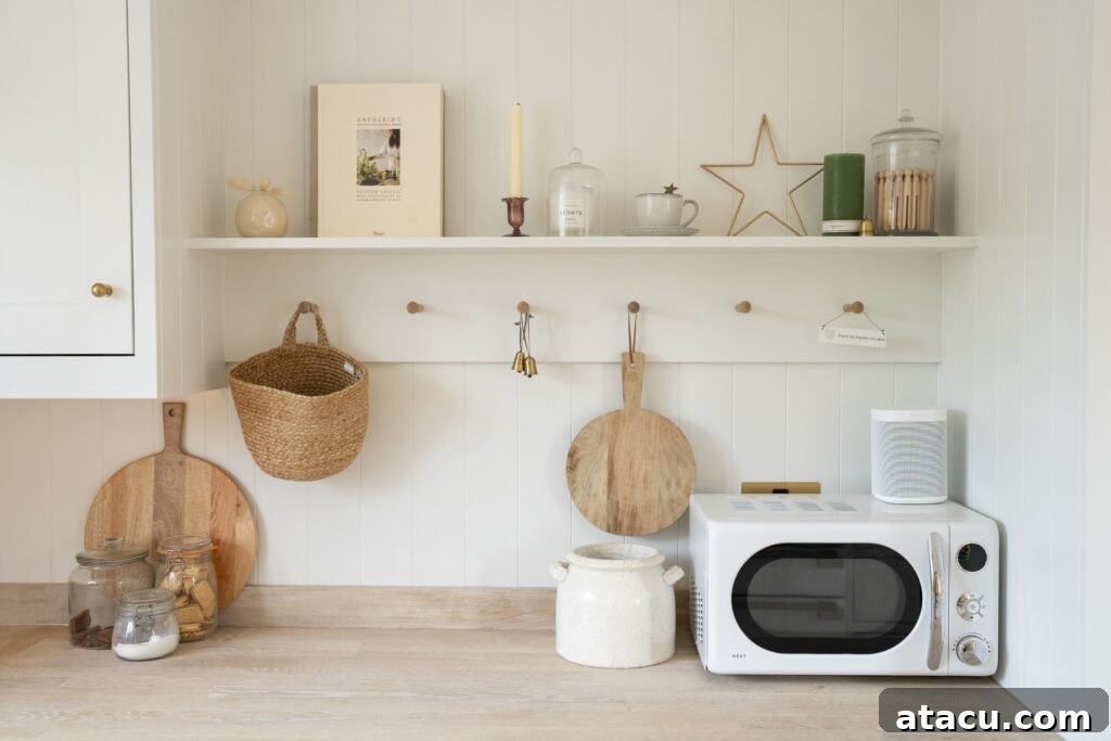 A cozy small kitchen featuring white cabinetry, wooden countertops, and functional hooks and a pegboard for hanging baskets and utensils, offering practical small kitchen ideas.