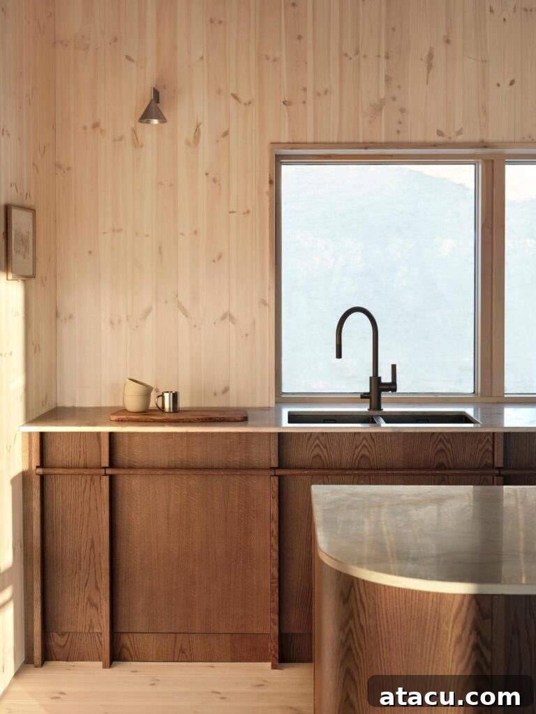 Minimalist kitchen featuring warm wood kitchen cabinets and a sleek black faucet by a large window, bathed in natural light.