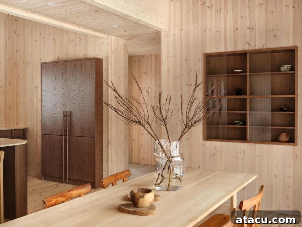 Bright dining area in a Swedish mountain home, featuring natural wood finishes, modern cabinetry, and minimalist decor for an open feel.