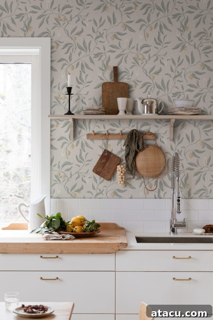 Kitchen with soft botanical wallpaper featuring lemons and greenery above white cabinets with wooden accents.