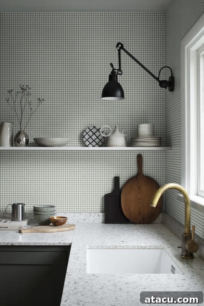 A kitchen with soft green gingham wallpaper, terrazzo countertops, and brass and black metal accents.