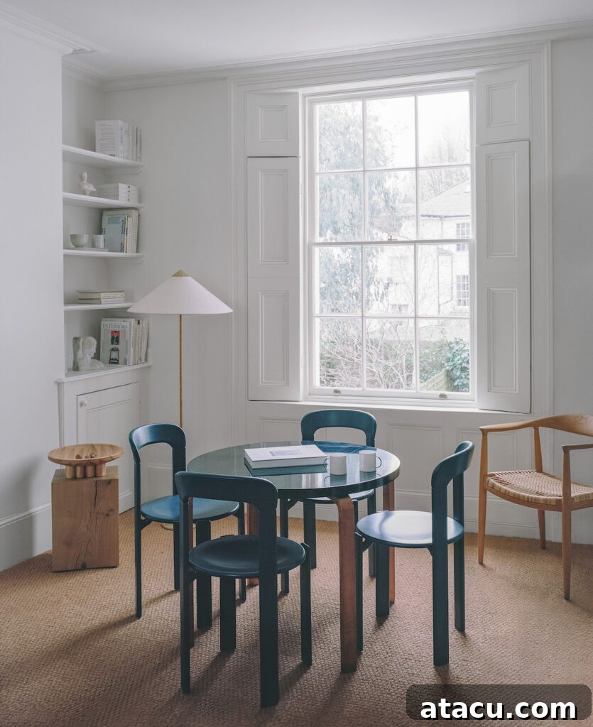 A light-filled living space in a Georgian home renovation with built-in shelving, modern furnishings, and natural textures.