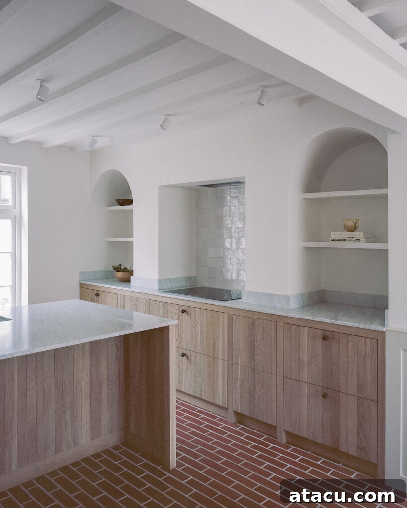 A renovated Georgian kitchen with natural wood cabinetry, marble countertops, and brick tile flooring for a warm, timeless look.