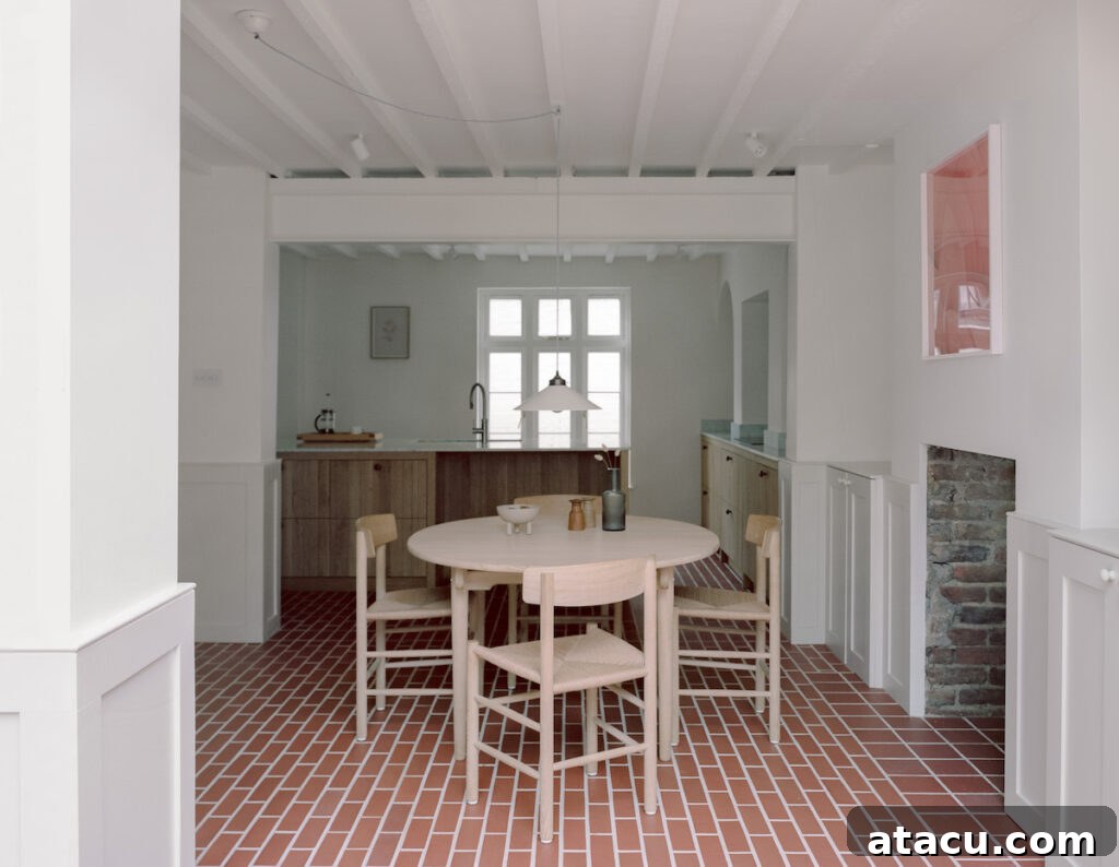 An open-plan dining and kitchen space in a Georgian home renovation with minimalist decor and natural materials.