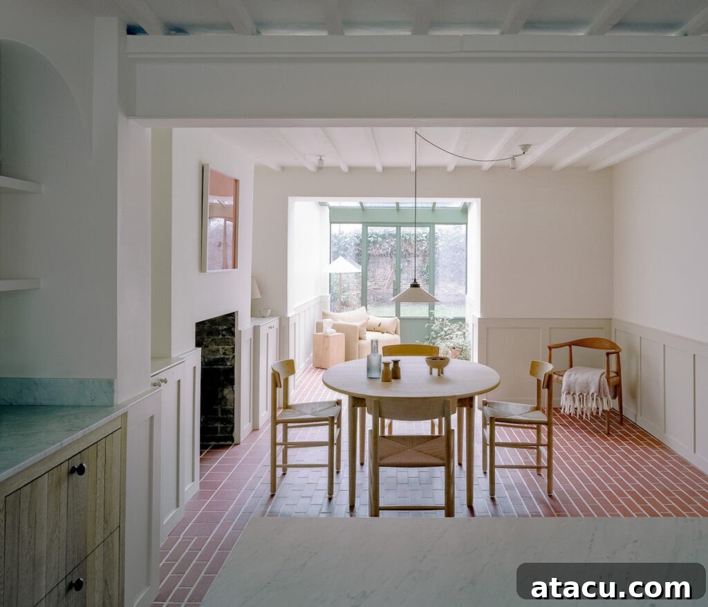 A bright dining area in a Georgian house restoration with wooden furniture, brick flooring, and a view of the sunroom.