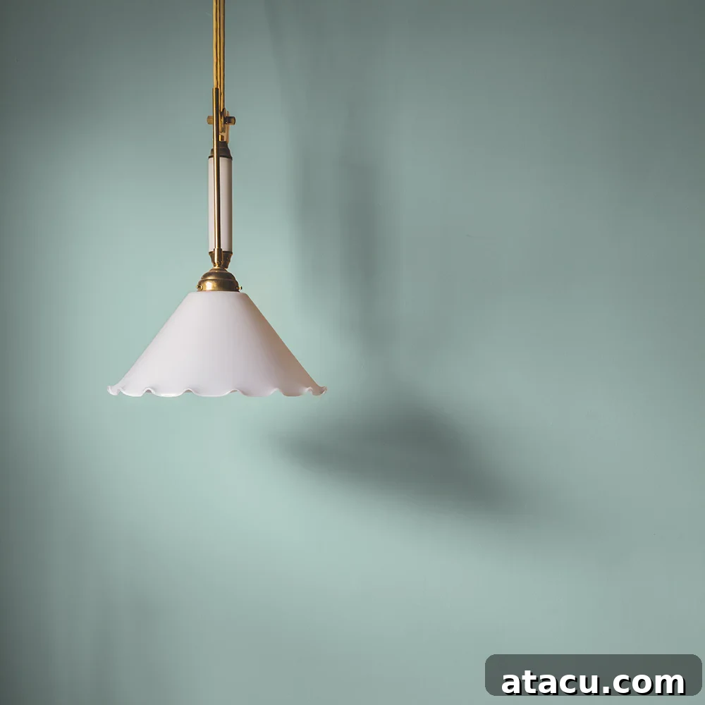 Curated Duck Egg Blue Paint Colors by Top Brands 14 A stylish room with a pendant light against a duck egg blue wall painted in Coat Paint's Free Range, highlighting its fresh, contemporary blue-green hue and ultra-matte finish.