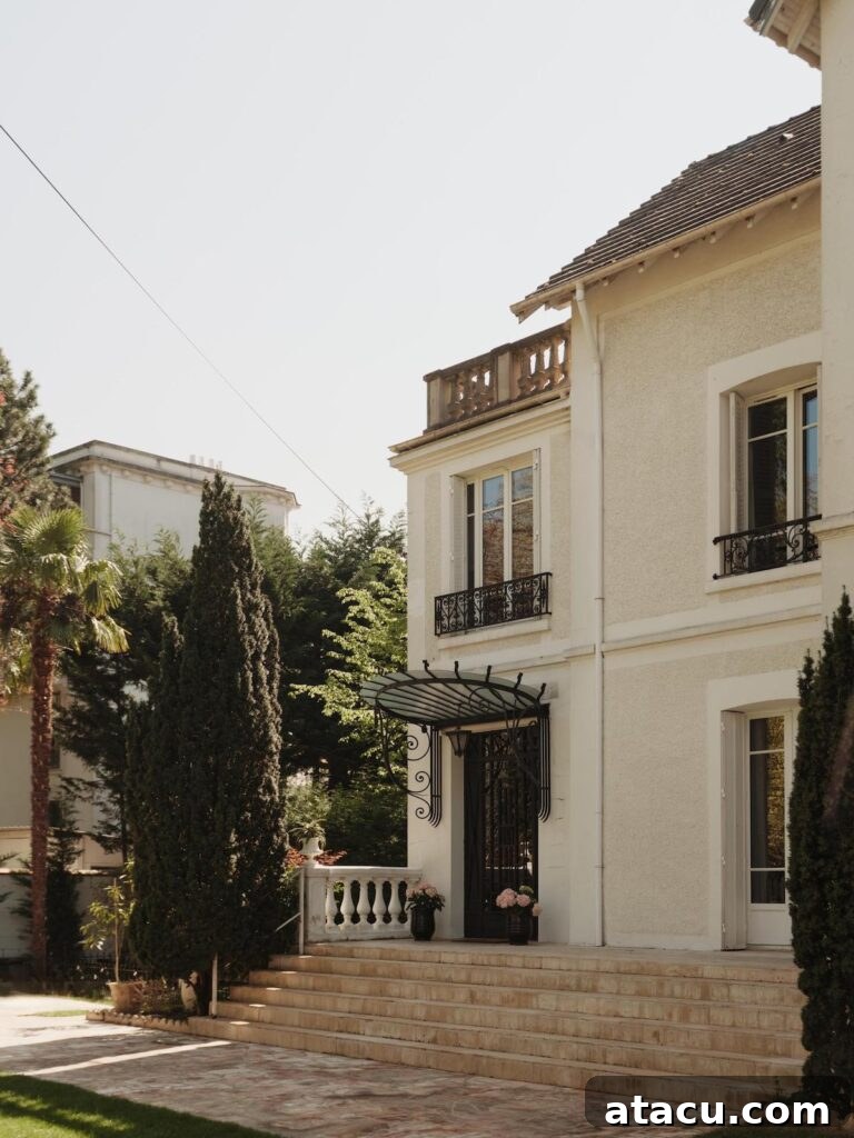 Elegant Parisian Belle Epoque home exterior with detailed wrought iron balconies and stucco walls, showcasing classic French architectural charm.