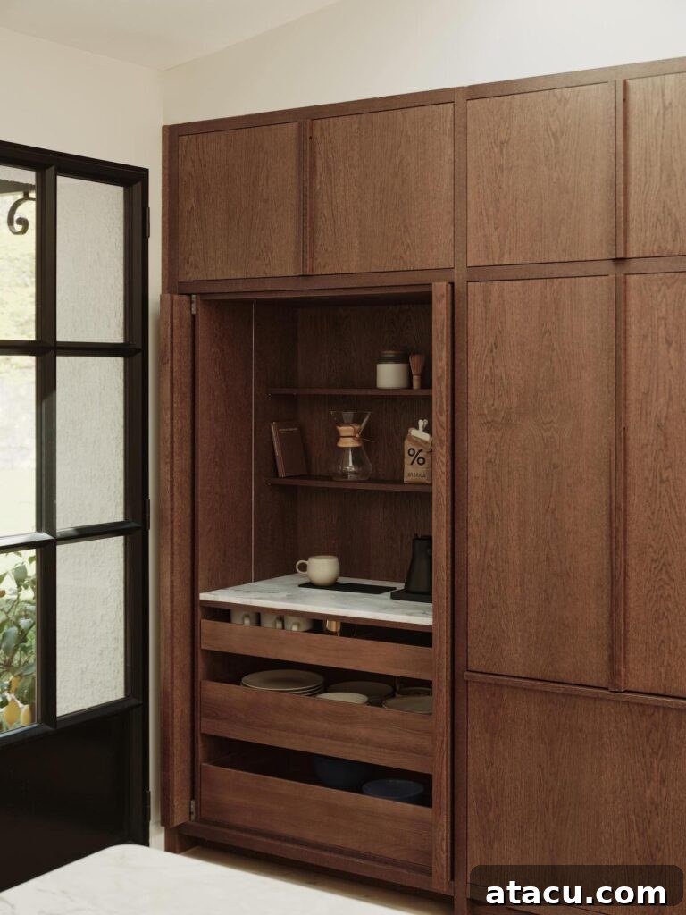 Custom wooden kitchen cabinetry with fully integrated storage and a sleek marble coffee station, epitomizing minimalist design.