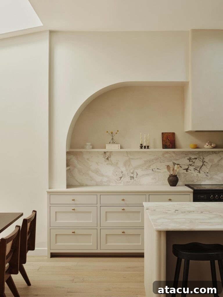 Contemporary kitchen featuring a pristine marble backsplash, a stylish wood dining set, and abundant natural light streaming from a large skylight.