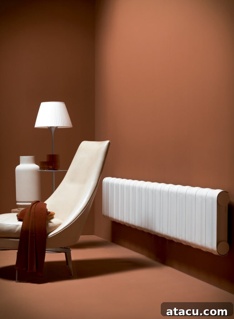 A sleek white horizontal designer radiator against a warm terracotta wall in a contemporary reading nook, featuring a modern chair and decorative elements.