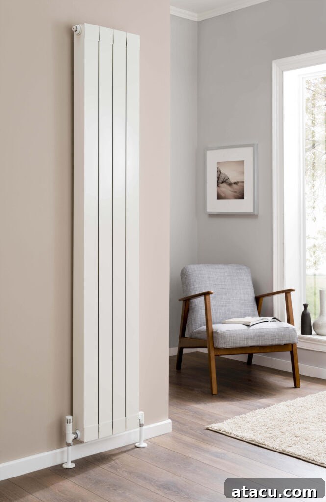 A slim white vertical radiator complements a cozy reading corner, featuring a mid-century modern armchair, soft lighting, and decorative plants.