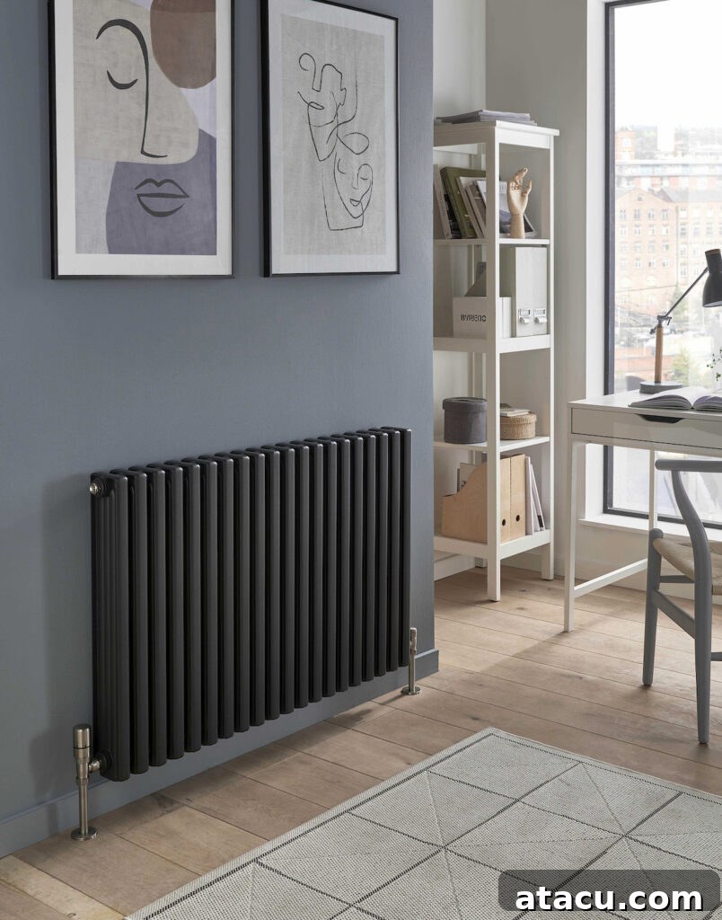 A stylish grey column radiator beneath abstract wall art in a minimalist home office, featuring clean lines and a modern aesthetic.
