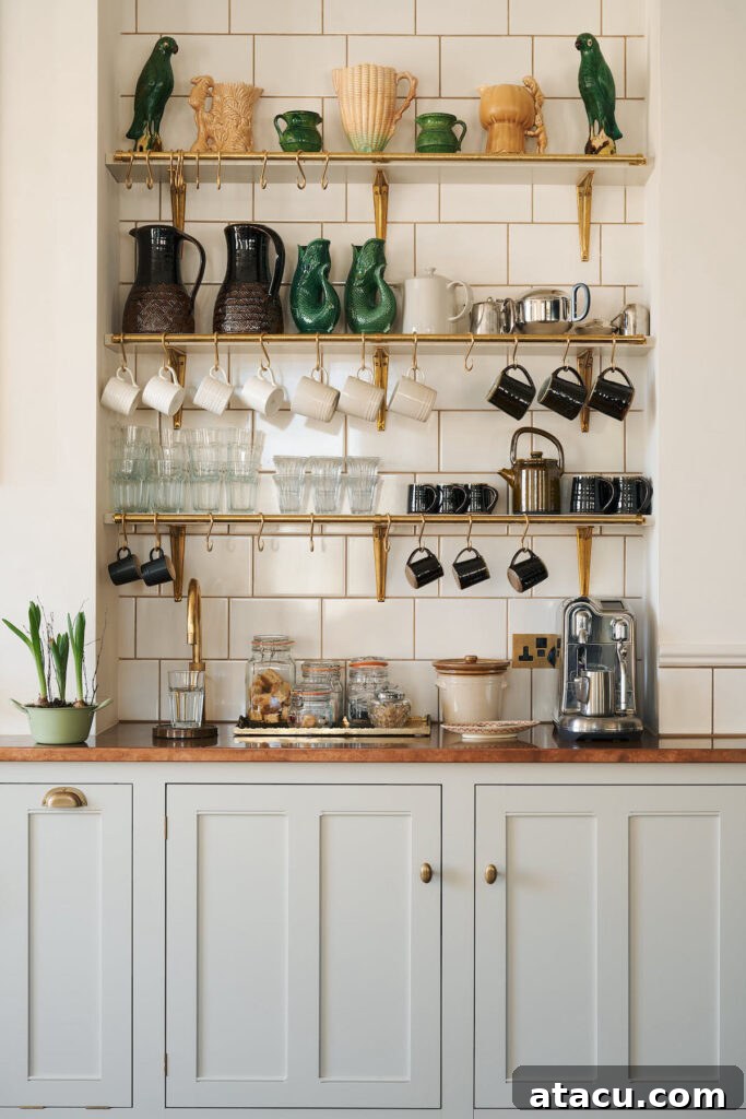 Elegant coffee station with brass shelves, hanging mugs, and vintage green pottery on a patterned tiled backsplash, complemented by a copper worktop.
