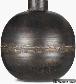 A striking recycled iron vase in black by Nkuku, ideal for displaying natural branches or sculptural elements with modern flair.